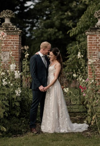Bride and Groom embracing in the gardens of Nether Winchendon House