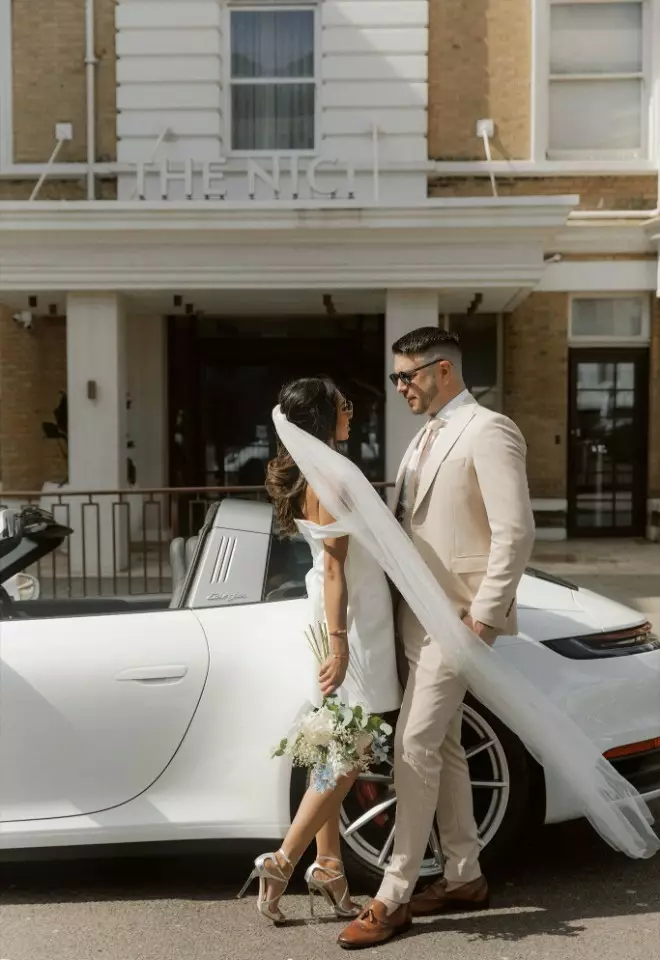 Bride & Groom stood by white porsche convertible car outside The Nici Hotel, Bournemouth, Dorset 