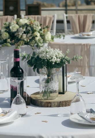 Wedding breakfast set up with small floral bouquets in mason jars on a yacht in cyprus