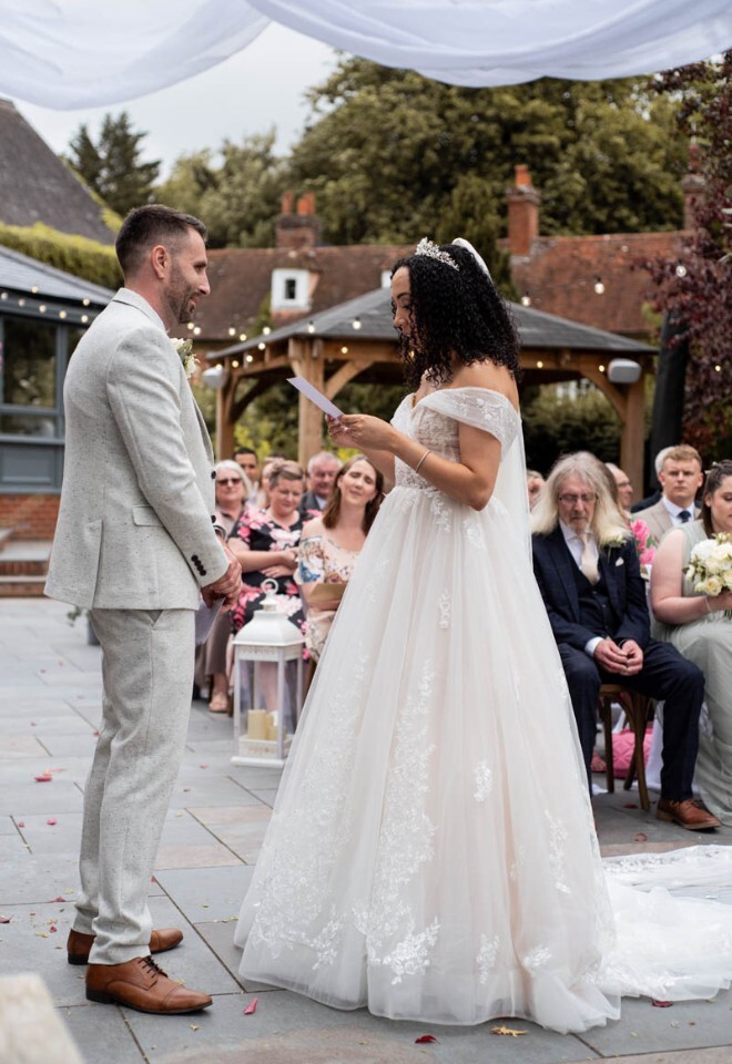 Bride and Groom exchange wedding vows during an outdoor ceremony.