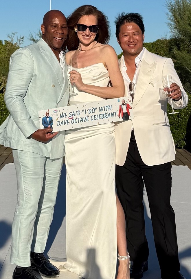 Dave Octave Celebrant with a happy bride and groom smiling and holding my We said I Do with Dave Octave Celebrant sign in St Tropez