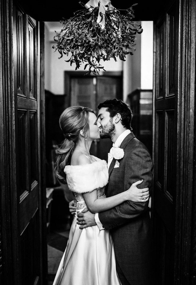 Bride and Groom kissing under mistletoe 