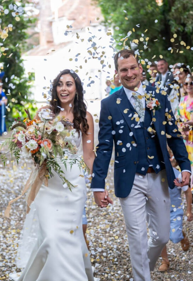 Bride and Groom walking through confetti