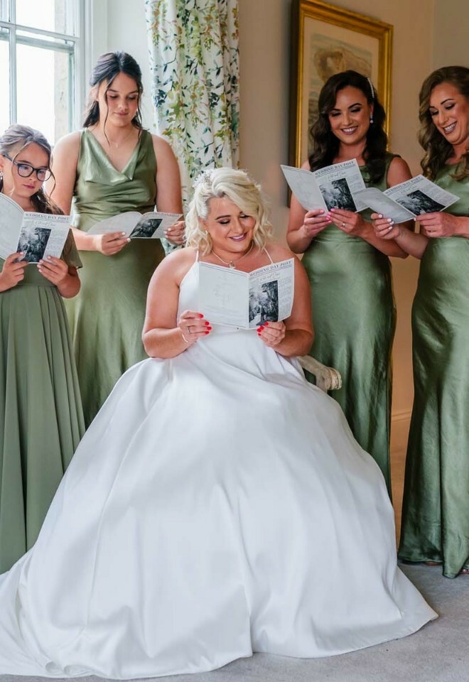 Bride along with her bridesmaids sitting and reading something in the room