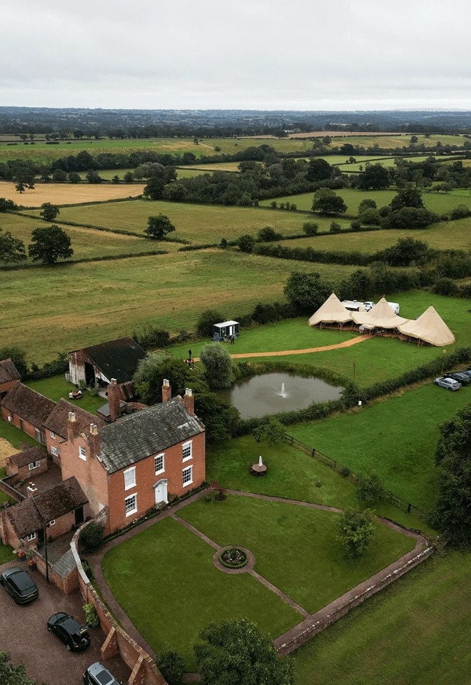 The Firs wedding venue from above, country house, barn and tipi can be seen