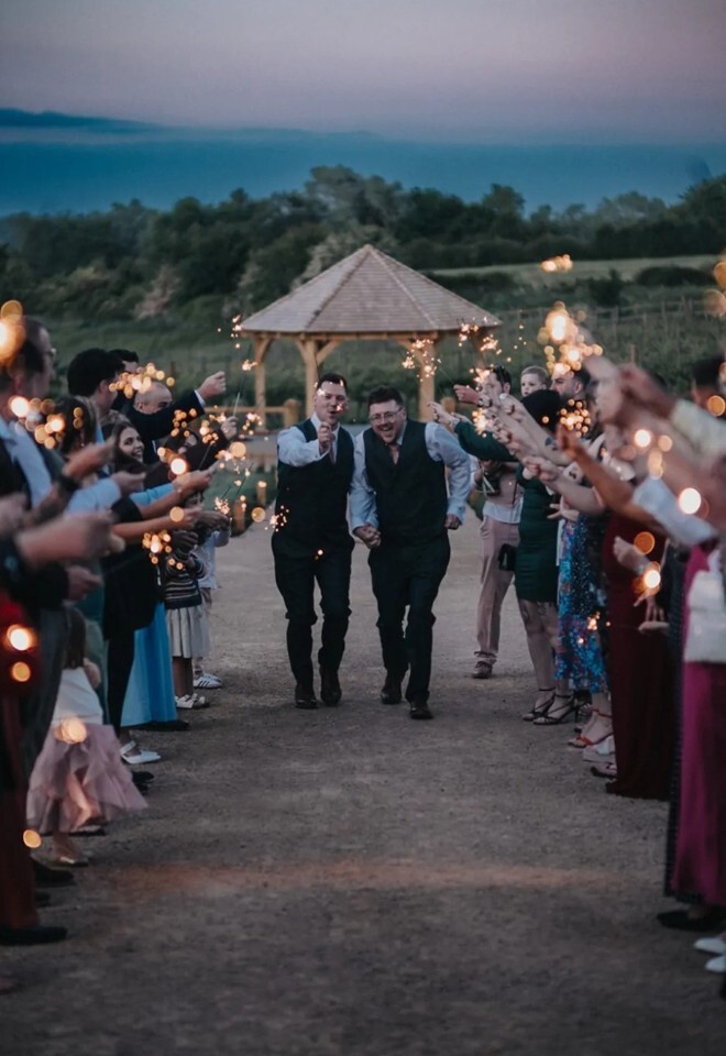 Sparkler exit with the outdoor ceremony space in the background at Copdock Hall