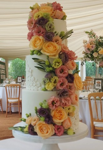 White 3 Tier Wedding Cake with Bas Relief Detailing and Fresh Flowers