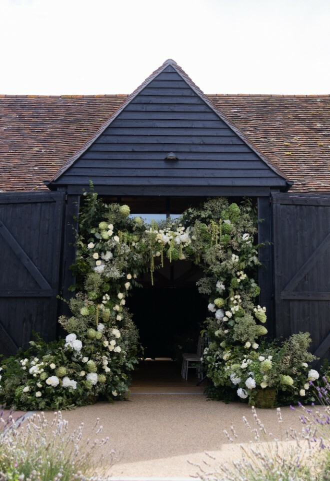 Exterior of the wedding barn with floral archway