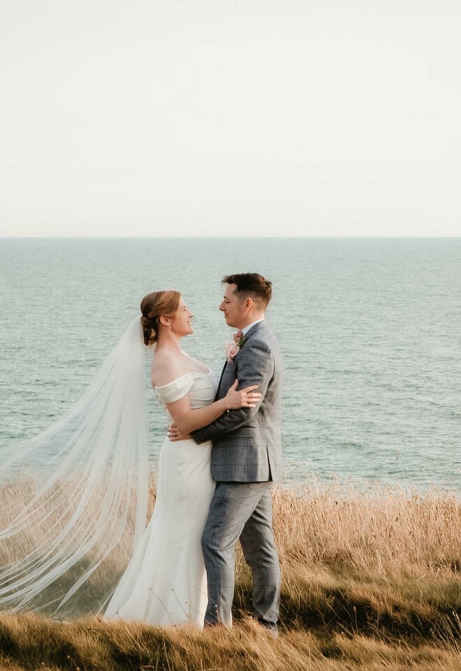 Elegant Isle of Wight wedding photography – couple embracing on clifftop with ocean view