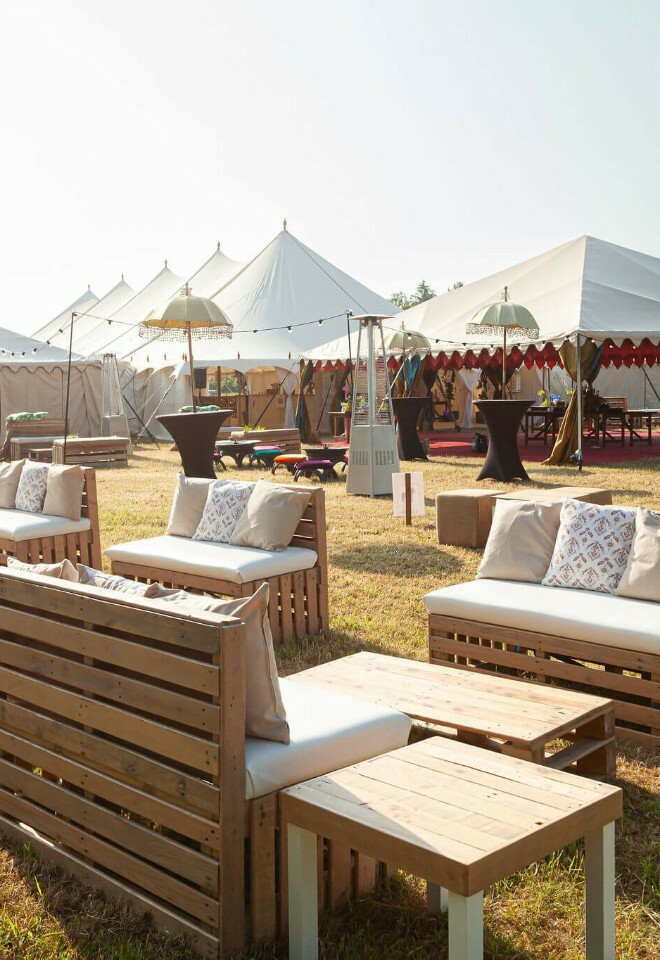 Multiple tent structure set up with pallet furniture outdoor seating 