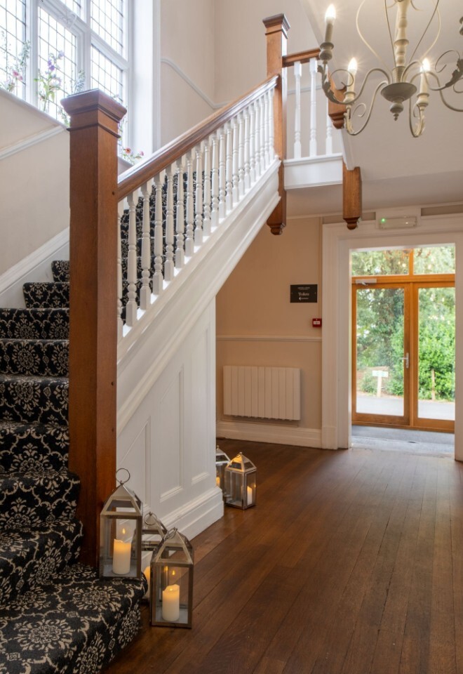 The grand foyer area and staircase in the manor house at a Warwickshire wedding venue