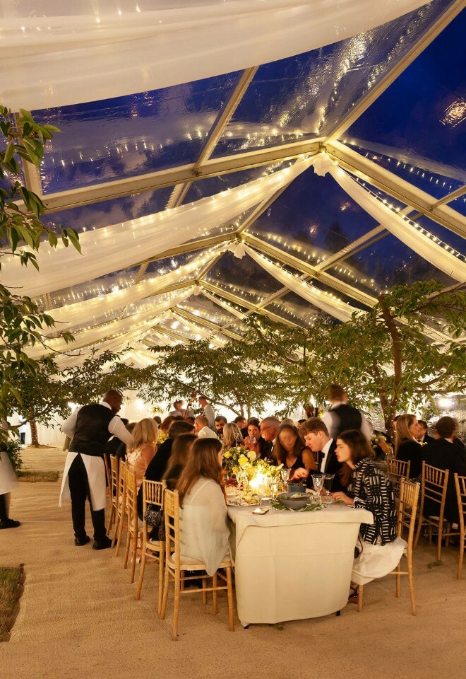 Luxury marquee with clear a clear roof and twinkling fairy lights, incorporating the orchards trees inside
