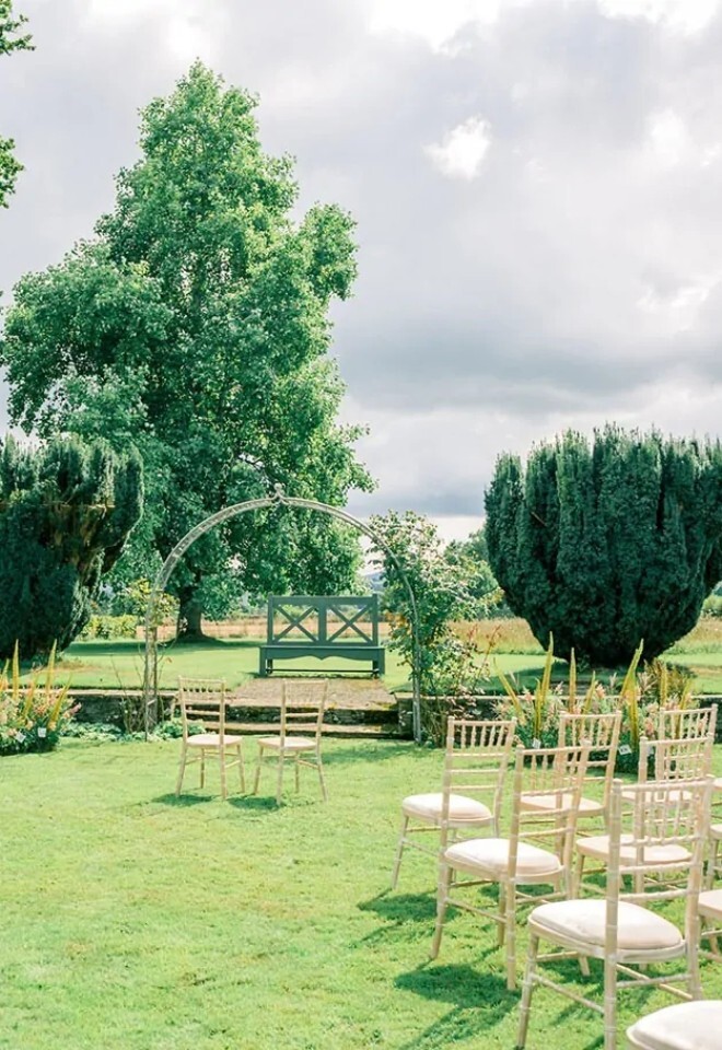 Outdoor wedding ceremony with gardens as backdrop