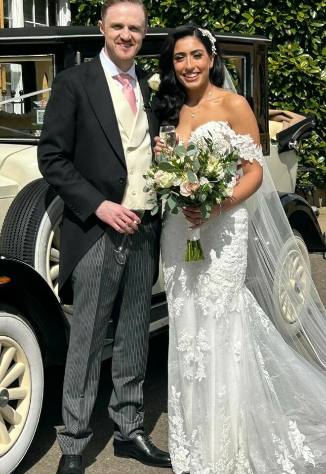 bride & groom raising a glass stood next to their vintage wedding car outside cotswold house hotel & spa