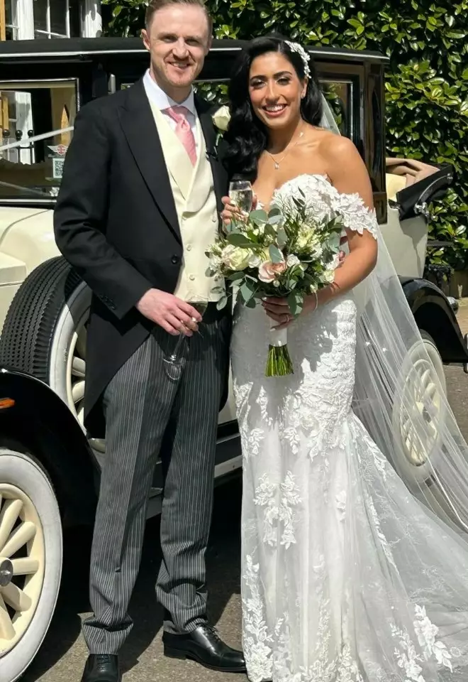 bride & groom raising a glass stood next to their vintage wedding car outside cotswold house hotel & spa
