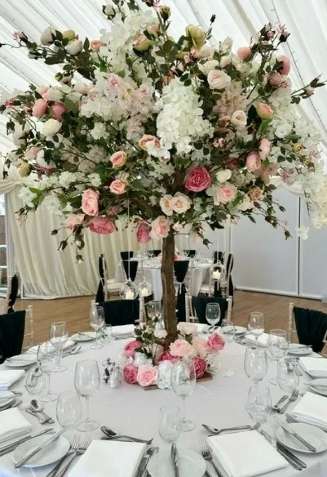 decorated table with floral tree as central decoration at wedding venue