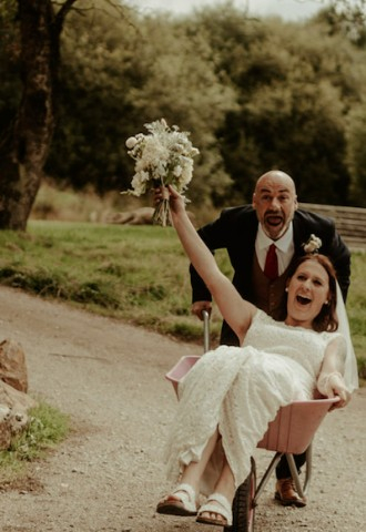 Groom pushes bride in wheelbarrow fun wedding picture Yorkshire
