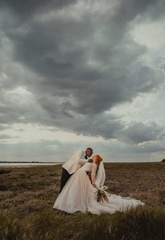 Bride and groom pose by the waterside at a Kent wedding venue