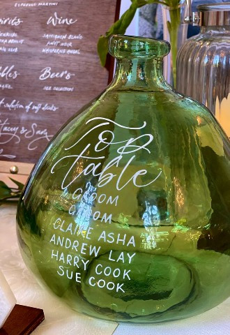 Green bottle table numbers with calligraphy and guest names 