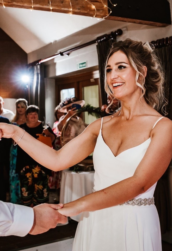 Bride and groom smiling as they share their first dance at The Cock O’Barton.