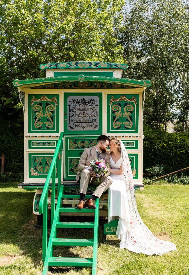 Bride and Groom sharing a special moment in front of the charming Romany Caravans at South Farm Wedding venue in Cambridshire