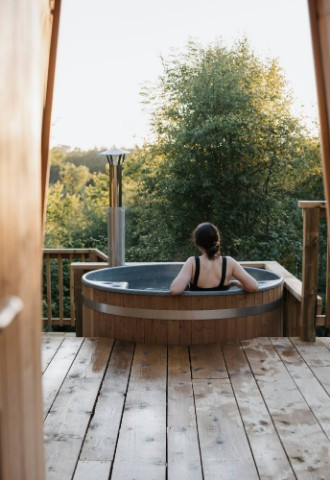 guest relaxing in hot tub in luxury tree yurt accomodation, eavestone lake