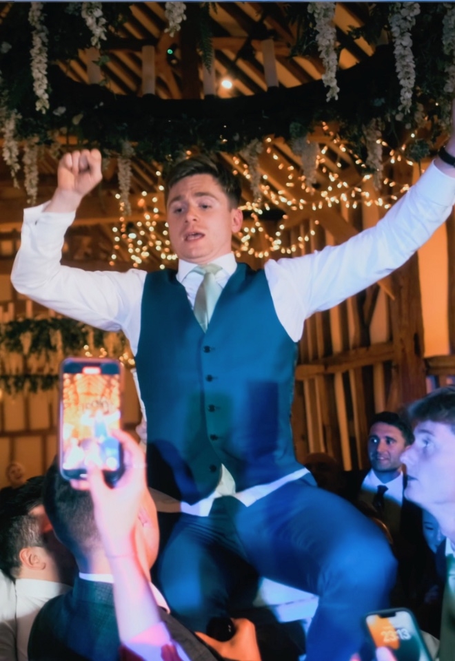 Guests lift groom in the air 