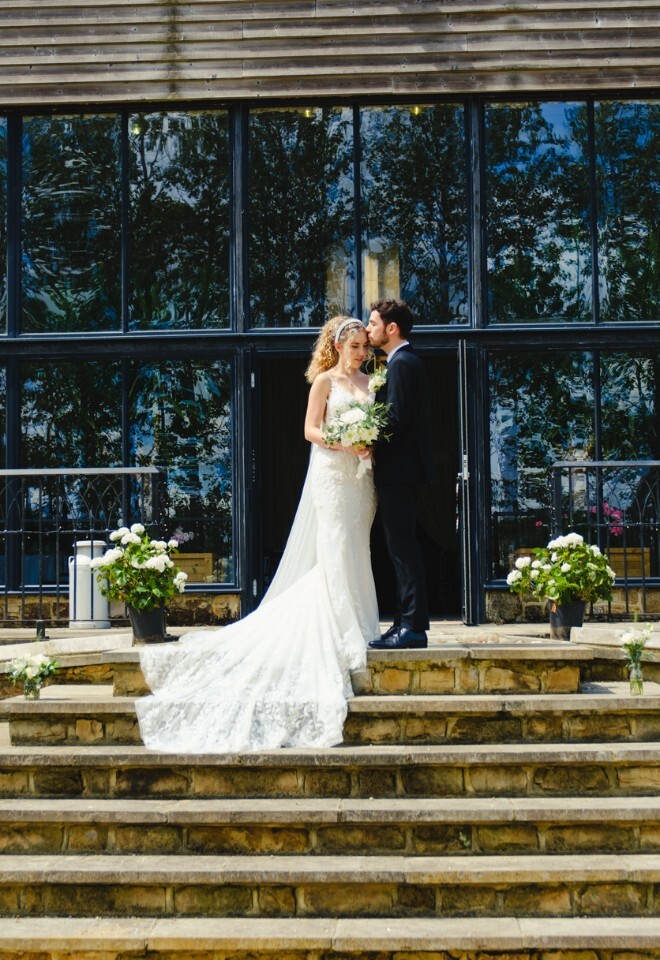 Bride and groom on steps outside Briar House Barns wedding venue in Rotherfield, East Sussex
