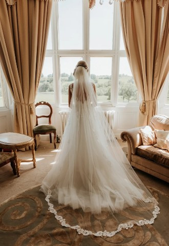 Bride getting ready in bedroom at Orchardleigh House