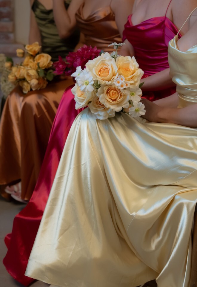 Bridemaids in colourful dresses, sitting