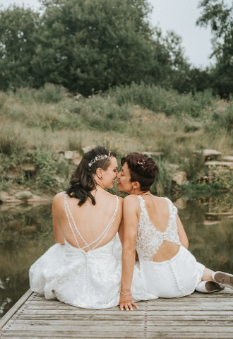 LGBTQ outside wedding couple kiss by pond