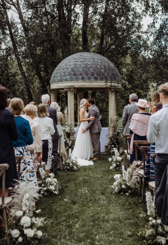Couple share first kiss as married couple at Minster Mill during outdoor wedding ceremony