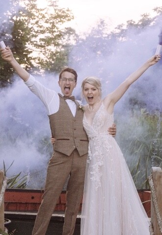 bride and groom holding smoke bomb
