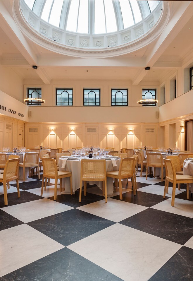 Wedding breakfast setup beneath the glass-domed ceiling at The Collector’s Hall wedding venue in Glasgow