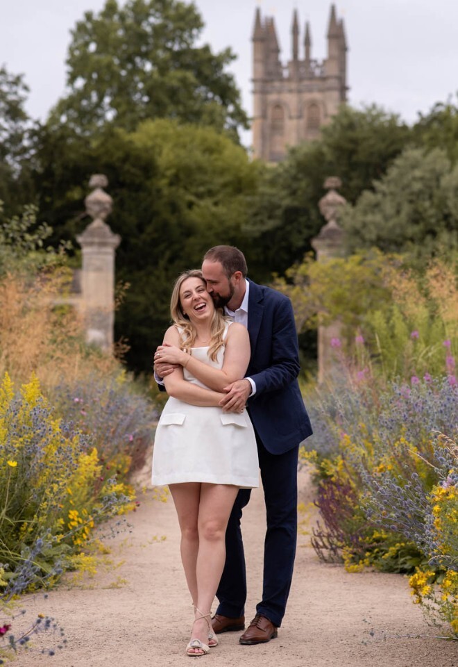 A happy couple hug in the Oxford Botanic Garden.