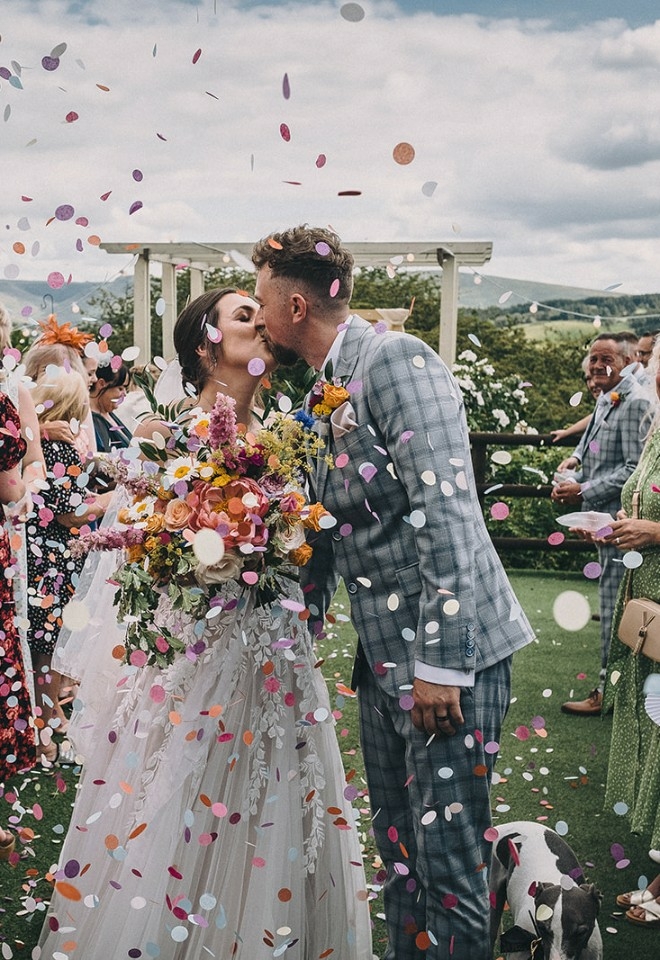 confetti image of couple kissing, dog friendly rustic wedding venue in Oldham
