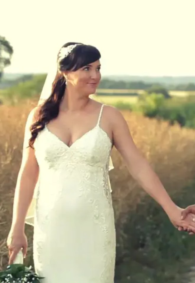 wedding couple holding hands while walking through a field by CKS productions in Berkshire