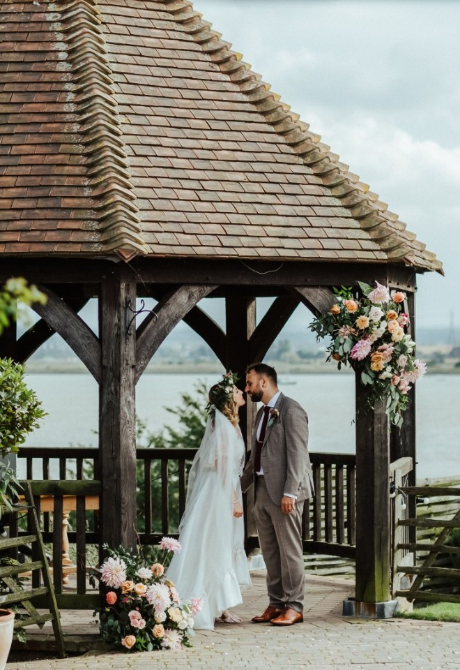 Bride and groom share a loving moment beneath The Harty Estates Oak Gazebo