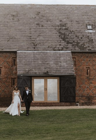 Wedding couple walking through grounds at Copdock Hall wedding venue Suffolk