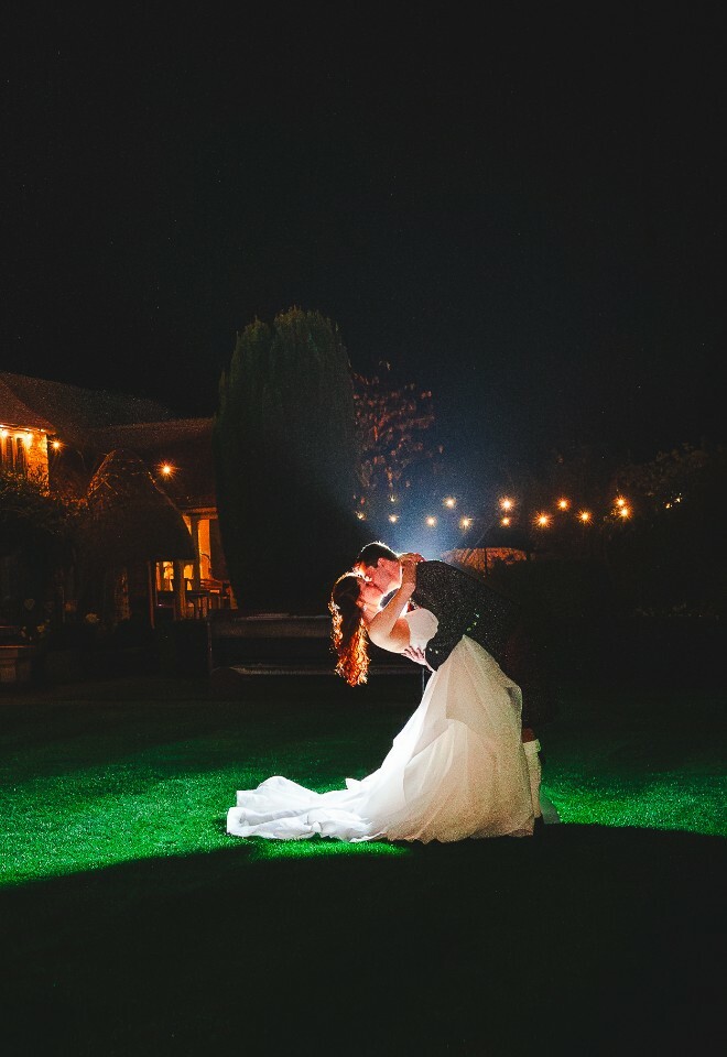 bride and groom outside farmhouse at night