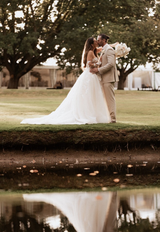 Bride and groom by lake at That Amazing Place Essex wedding venue