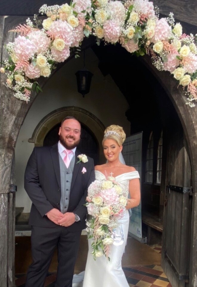 Bride and groom; shower bouquet and church fresh flower arch