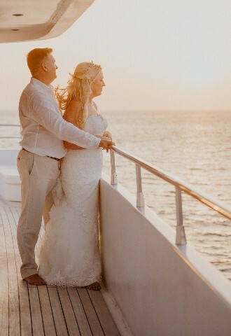 bride and groom watching the sunset on a yacht at their wedding reception