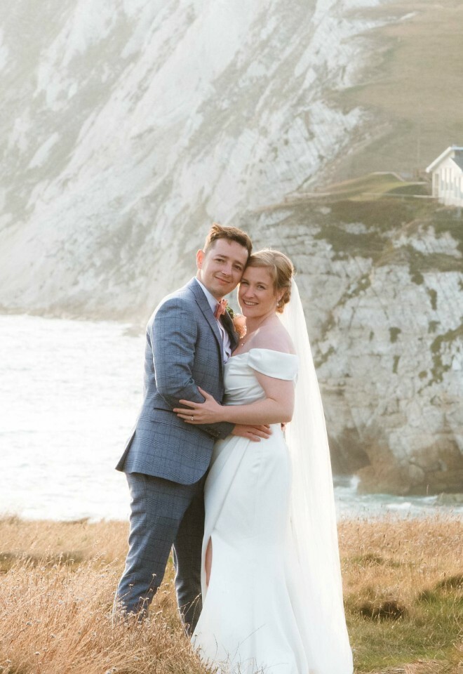 Romantic Isle of Wight wedding photography – couple embracing on cliffside at sunset