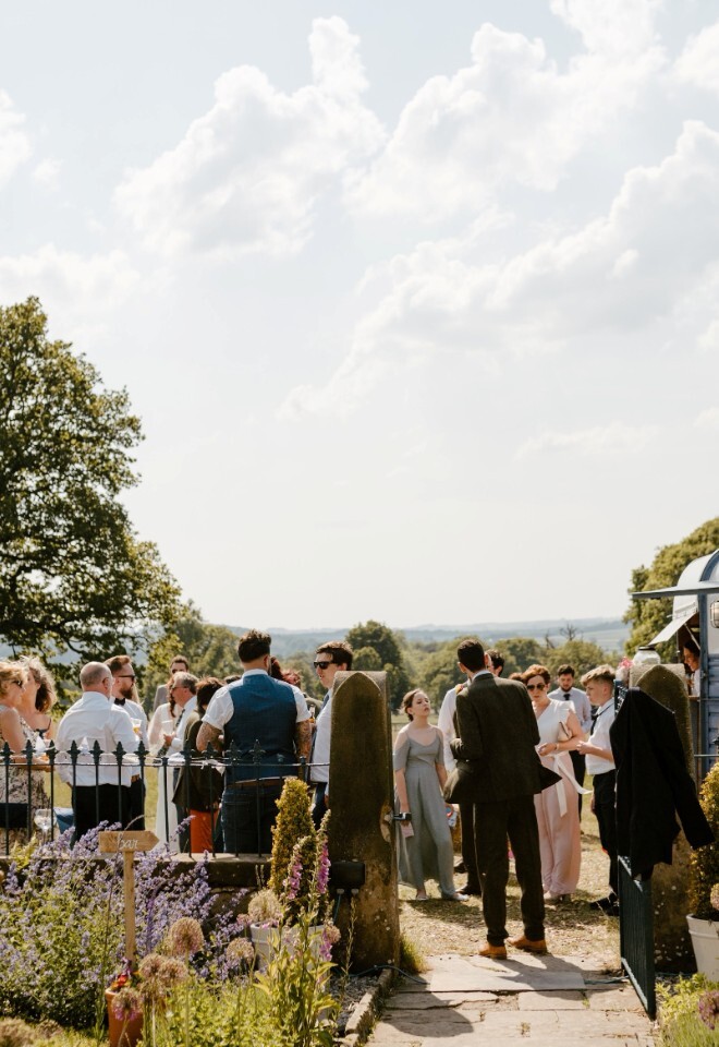 Wedding guests gathering on the lawn looking over the Chatsworth Estate with a drinks tailer 