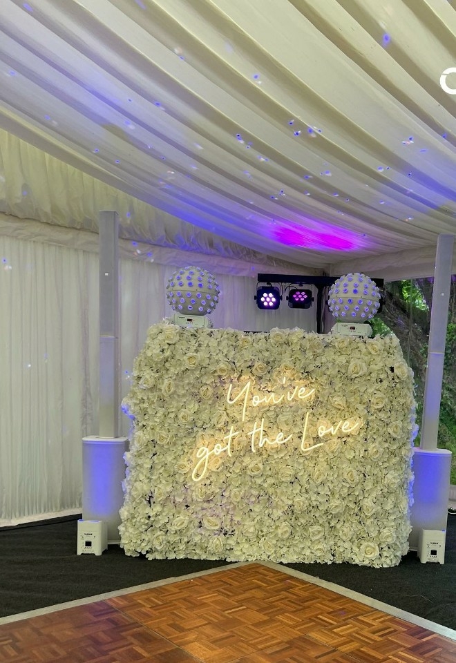 Marquee wedding reception with DJ booth in cream floral backdrop