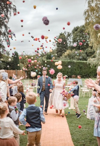 Bride and groom being showered in pom pom confetti, Glen Yr Afon House