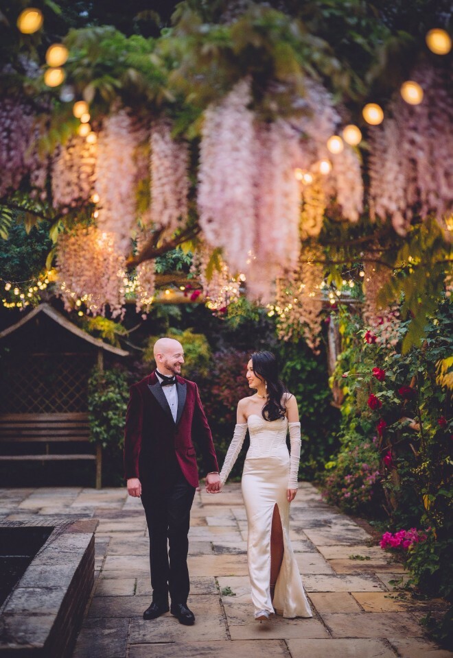 Couple photographed with wisteria in venue grounds