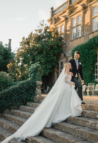Bride and Groom walking up the Terrace steps at Brympton House. Autumn Wedding Day.