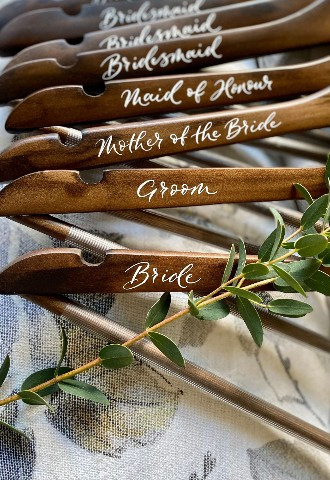 Personalised hand written dark wood wooden bridal party wedding hangers ordered from Mint Lettering calligraphy Buckinghamshire